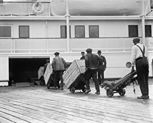 LOADING FREIGHT, c1924. Dockworkers loading cargo onto a steamship. Photograph, c1924