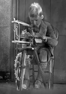 Boy operating a sewing machine